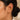 Close-up of a model's ear wearing a gold ear cuff earring with textured horizontal bands.